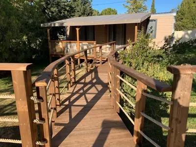 a patio with a table and chairs on a deck at Camping Les Hautes Prairies in Lourmarin