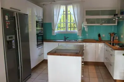 a kitchen with white cabinets and a refrigerator at Villa élégante à Villelaure + Clim in Villelaure
