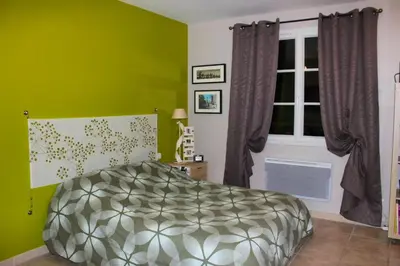 a green bedroom with a bed and a window at Villa élégante à Villelaure + Clim in Villelaure