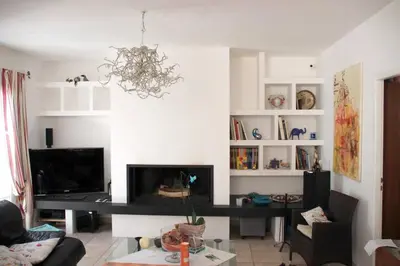 a living room with a fireplace and a chandelier at Villa élégante à Villelaure + Clim in Villelaure