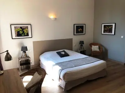 a bedroom with a bed and a table and chairs at MAISON LUBERON in Apt