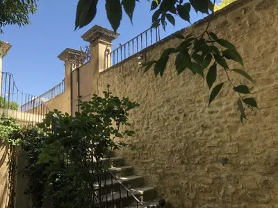 a stone wall with stairs leading up to a building at MAISON LUBERON in Apt