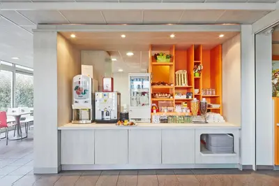 a restaurant with a counter with refrigerators at Premiere Classe Avignon Parc Des Expositions in Montfavet