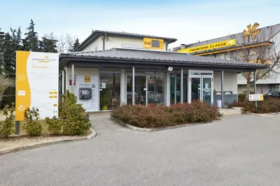 a building with a parking lot in front of it at Premiere Classe Avignon Parc Des Expositions in Montfavet