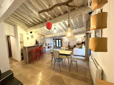 a dining room and living room with a table and chairs at Toits Vieil Aix - Appartement de charme avec terrasse d'exception centre ville historique proche Cardeurs Et Mairie in Aix-en-Provence