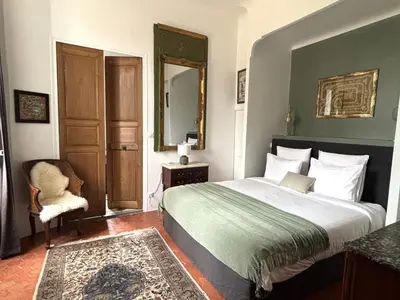 a bedroom with a bed and a mirror and a chair at Château de Saint-Girons - Luxury Guest House in Provence in Aix-en-Provence