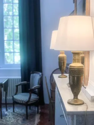 a lamp sitting on a table with a chair at Château de Saint-Girons - Luxury Guest House in Provence in Aix-en-Provence