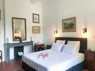 a bedroom with a bed with two flip flops on it at Château de Saint-Girons - Luxury Guest House in Provence in Aix-en-Provence
