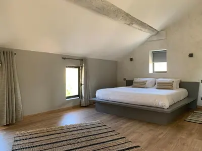 a bedroom with a large bed with white sheets and pillows at MAS aux CEDRES in Lioux