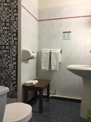 a bathroom with a sink and a toilet and a table at Hotel du Midi in Salon-de-Provence