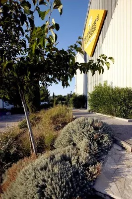 a sign on the side of a building with plants at Premiere Classe Salon De Provence in Salon-de-Provence