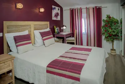 a bedroom with a large bed with purple walls at Hotel Toppin in Cavaillon