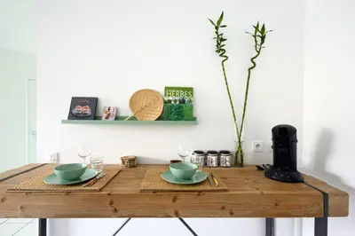 a wooden table with two plates and glasses on it at T2 cosy proche du centre-ville avec garage inclus in Aix-en-Provence