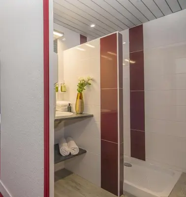 a bathroom with a shower with a glass door at Hotel du Forum in Carpentras