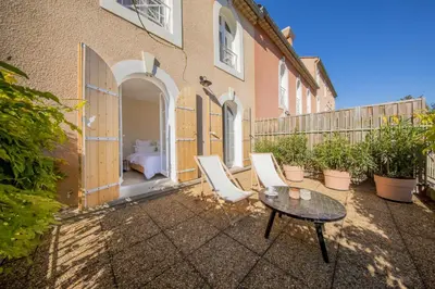 a patio with chairs and a table in front of a building at Moulin de la Roque in Althen-des-Paluds