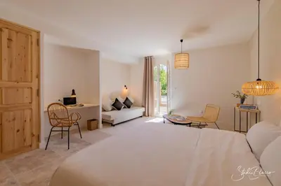 a bedroom with a bed and a living room at Moulin de la Roque in Althen-des-Paluds