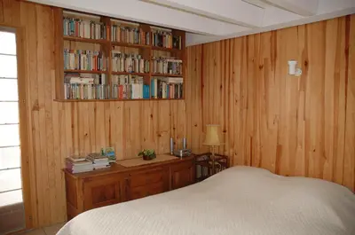 a bedroom with a bed and a book shelf with books at L'Atelier de Maia in Mormoiron