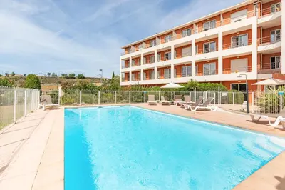 a swimming pool in front of a building at Appart'City Classic Aix-en-Provence - La Duranne in Aix-en-Provence