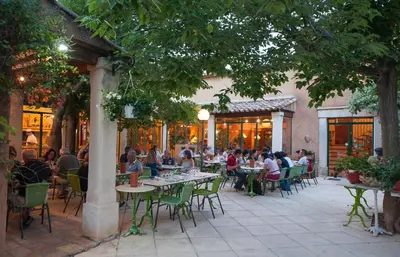 a group of people sitting at tables outside a restaurant at Mas De La Tour in Gargas