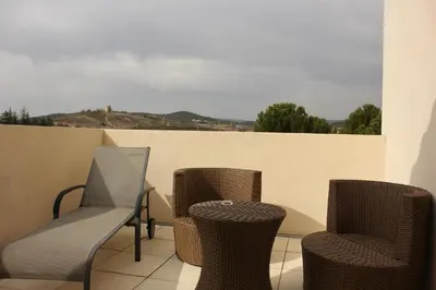 three chairs and a table on a balcony at Logis Hôtel Le Manoir - Luberon in Apt