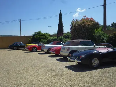 a row of old cars parked in a parking lot at Logis Hôtel Le Manoir - Luberon in Apt