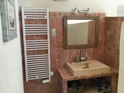 a bathroom with a sink and a mirror at typical provencal bastide, built of local stones, in the luberon in cheval-blanc with secured pool and wifi -sleeps 6 people. in Cheval-Blanc