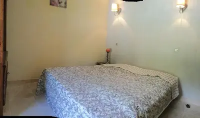 a bedroom with a bed and two lights on the wall at typical provencal bastide, built of local stones, in the luberon in cheval-blanc with secured pool and wifi -sleeps 6 people. in Cheval-Blanc