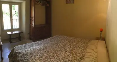 a bedroom with a bed and a window at typical provencal bastide, built of local stones, in the luberon in cheval-blanc with secured pool and wifi -sleeps 6 people. in Cheval-Blanc
