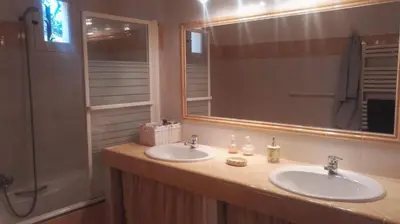 a bathroom with two sinks and a large mirror at Le Samaro in Puyvert