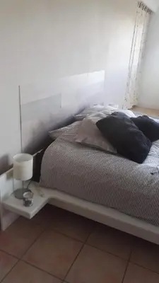 a bedroom with a large bed with a white headboard at Le Samaro in Puyvert