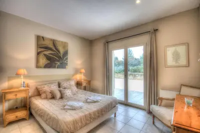 a bedroom with a bed and a sliding glass door at Mas Santoline in Eygalières