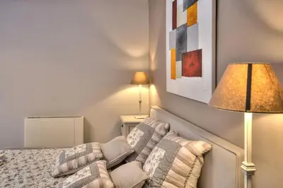 a bedroom with a bed with a lamp and a couch at Mas Santoline in Eygalières