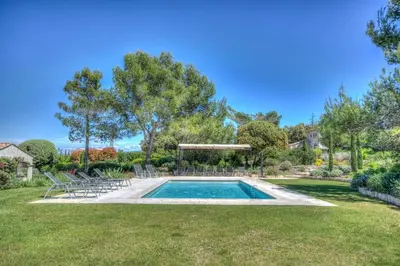 a swimming pool in a yard with chairs at Mas Santoline in Eygalières