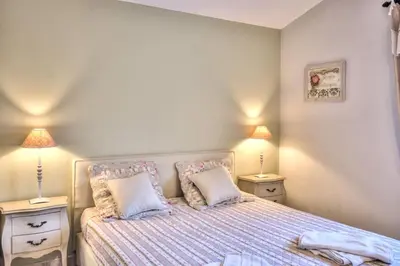 a bedroom with a bed with two night stands and two lamps at Mas Santoline in Eygalières