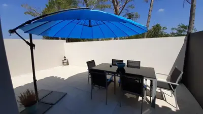 a table with a blue umbrella on a patio at Villa Quatra aux portes d'Aix-en-Provence in Éguilles