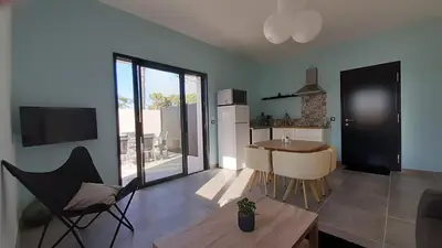 a living room with a kitchen with a table and chairs at Villa Quatra aux portes d'Aix-en-Provence in Éguilles
