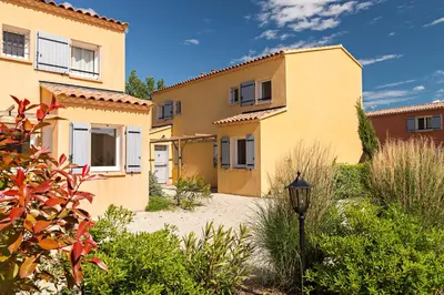 a yellow house with a street light in front of it at Lagrange Vacances L’Oustau de Sorgue in LʼIsle-sur-la-Sorgue