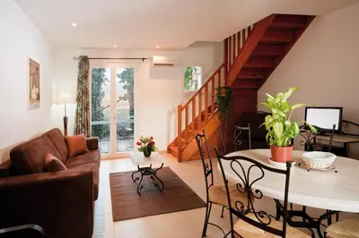 a living room with a couch and a table at Lagrange Vacances L’Oustau de Sorgue in LʼIsle-sur-la-Sorgue