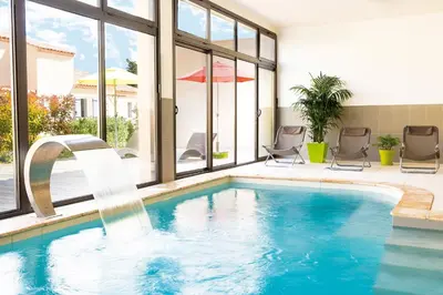 a swimming pool with a water fountain in a house at Lagrange Vacances L’Oustau de Sorgue in LʼIsle-sur-la-Sorgue