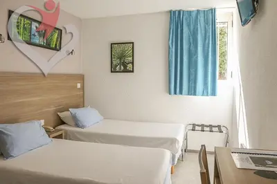 a hotel room with two beds and a window at HOTEL RESTAURANT OLYMPE in Aix-en-Provence