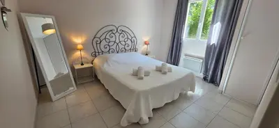 a bedroom with a bed with two candles on a table at Les dentelles Évasion Provençale Villa avec Piscine et jardin in Carpentras
