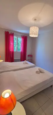 a bedroom with two beds and pink curtains at Les dentelles Évasion Provençale Villa avec Piscine et jardin in Carpentras