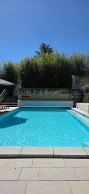 a swimming pool with blue water in a yard at Gîte Charmant avec Piscine et Terrasse en Provence MDV in Carpentras