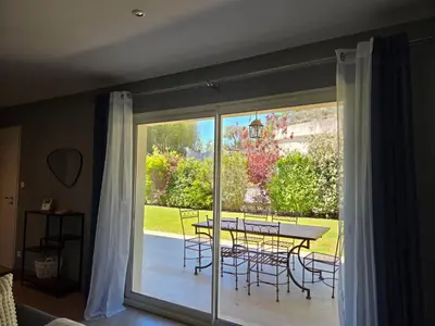 a sliding glass door with a table and chairs on a patio at Paradis Provençal Villa - Espace Détente et BBQ LMV in Carpentras