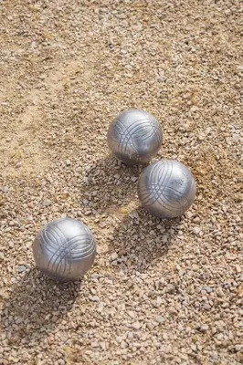 three metal balls are sitting on the ground at Résidence Les Académies Aixoise in Aix-en-Provence