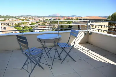 two chairs and a table on a balcony with a view at Résidence Les Académies Aixoise in Aix-en-Provence