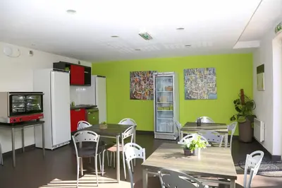 a dining room with green walls and tables and chairs at Résidence Les Académies Aixoise in Aix-en-Provence