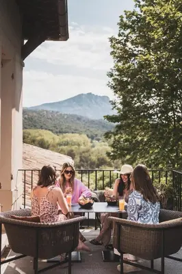 a group of women sitting at a table on a patio at Les Lodges Sainte-Victoire Hotel & Spa in Aix-en-Provence