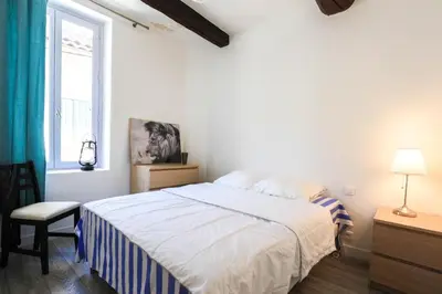 a white bedroom with a bed and a window at ROGERIO en PLEIN CENTRE DE L'ISLE SUR SORGUE in LʼIsle-sur-la-Sorgue