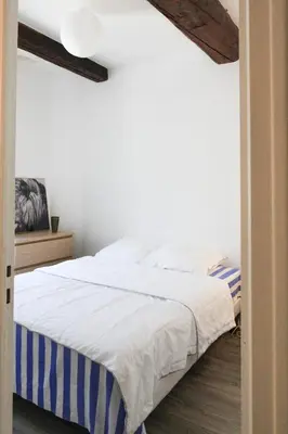 a bedroom with a bed with a blue and white blanket at ROGERIO en PLEIN CENTRE DE L'ISLE SUR SORGUE in LʼIsle-sur-la-Sorgue
